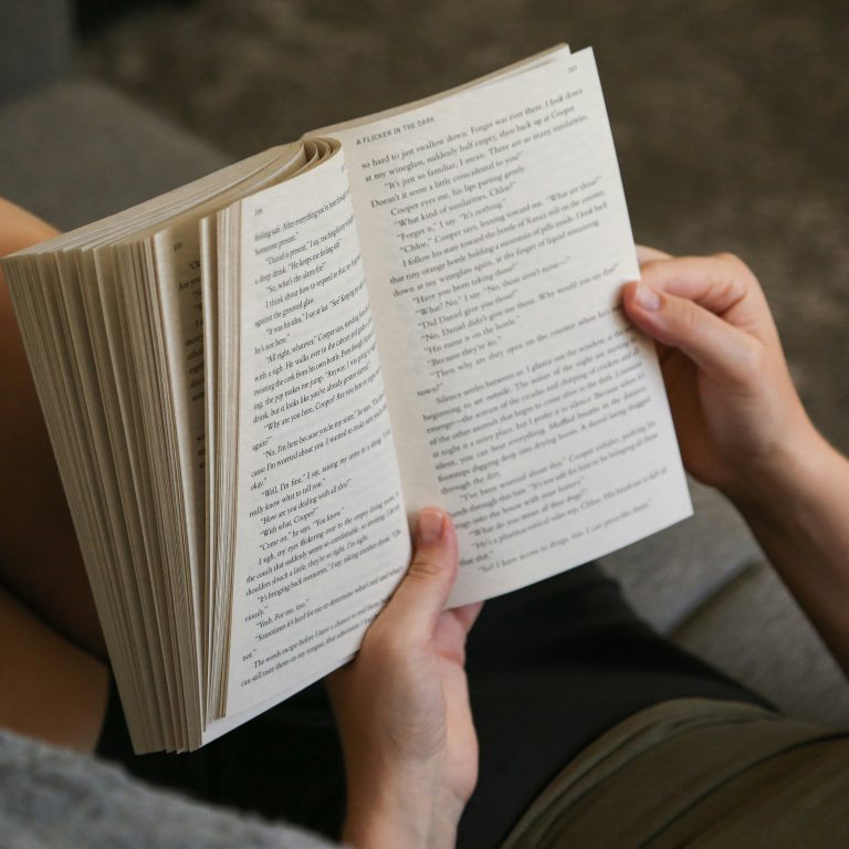 imatge petita llibre obert entre mans llegint